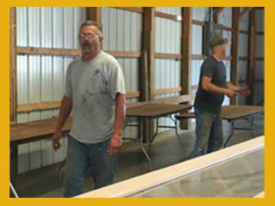 Two men setting up exhibits in Barn 4