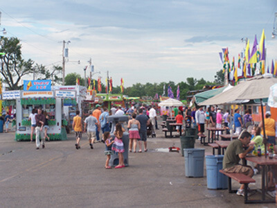 People eating at outdoor vendors and walking along the midway